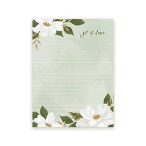 A note pad with white flowers and leaves on it.