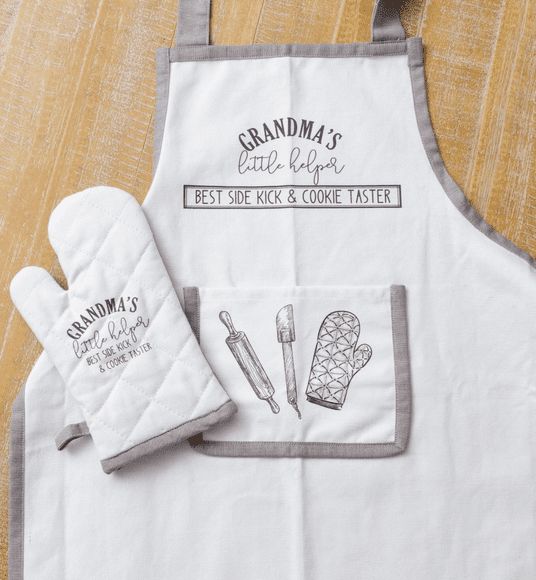 A white apron and oven mitt with an oven mitt, spatula and rolling pin.