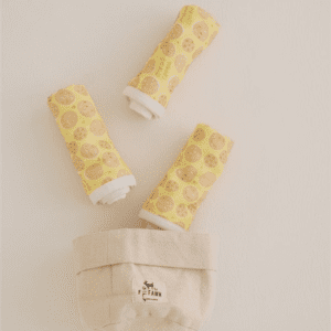 Three yellow spools of thread sitting on top of a table.