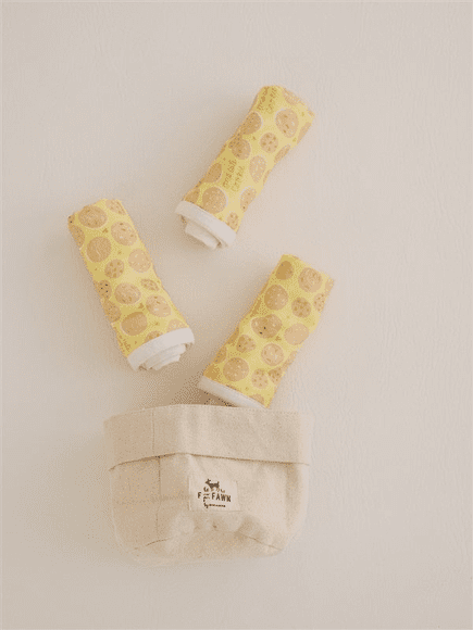 Three yellow spools of thread sitting on top of a table.