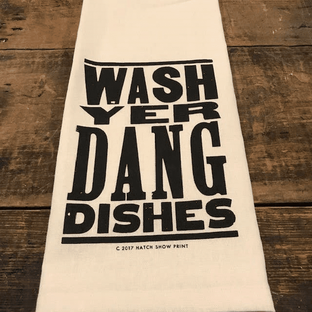 A towel that says " wash yer dang dishes ".