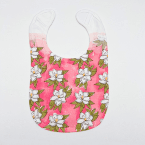 A pink bib with white flowers on it.