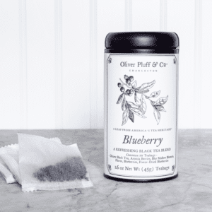 A tea bag sitting next to a container of blueberry.