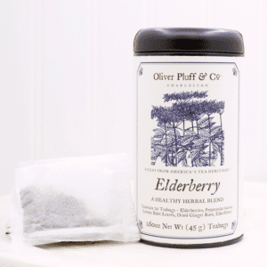 A tea bag sitting next to a can of elderberry.