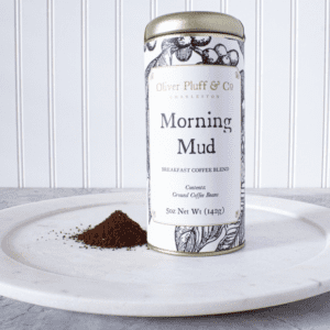 A tin of coffee sitting on top of a white plate.