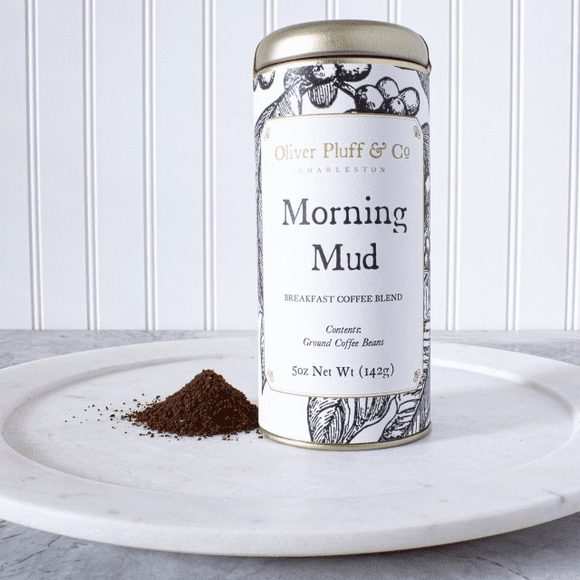 A tin of coffee sitting on top of a white plate.