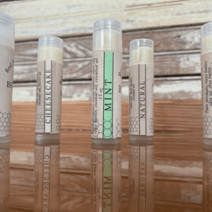 Five flavored lip balm tubes on wood.