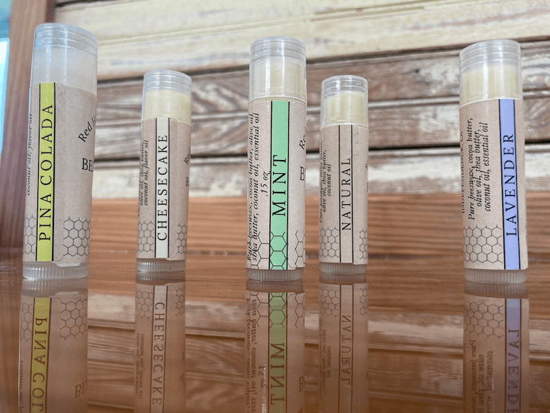 Five flavored lip balm tubes on wood.