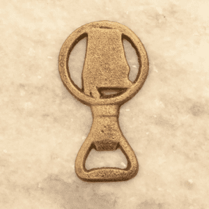 A gold bottle opener sitting on top of a table.