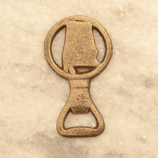 A gold bottle opener sitting on top of a table.