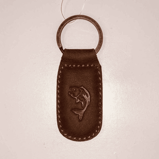 A brown leather key chain with a fish on it.