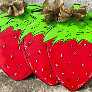 A pair of strawberries with burlap bow on top.