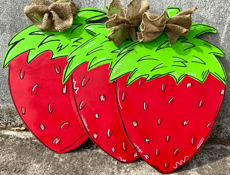 A pair of strawberries with burlap bow on top.