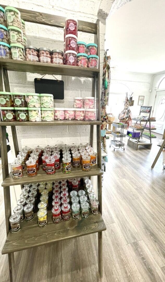 Wooden shelves with various jars of candy.