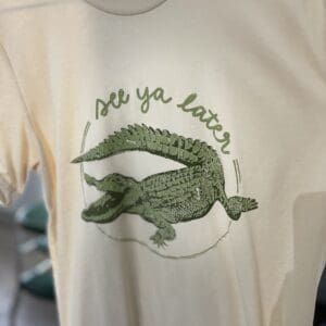 A close up of the front of a shirt with an alligator on it