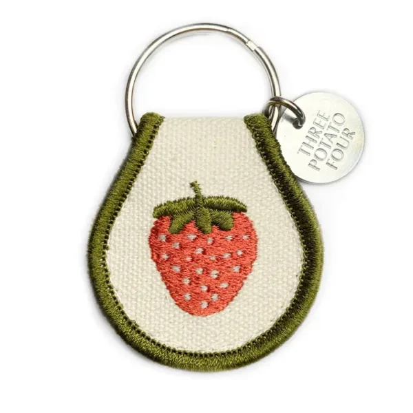 Green and white keychain with a strawberry.