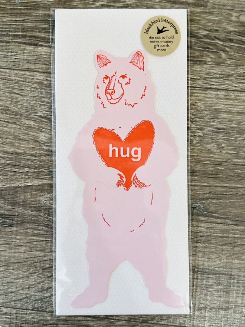 Pink bear holding a red heart that says "hug"