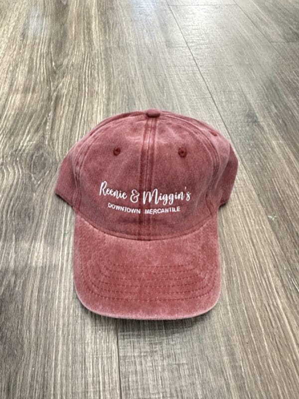 Red baseball cap with "Reenie & Miggin's" logo.