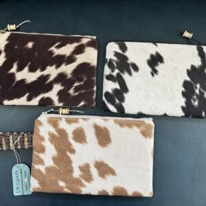 Three cowhide zippered pouches with tags.