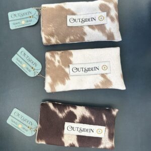 Three cow print pouches with "Outsidein" logo.