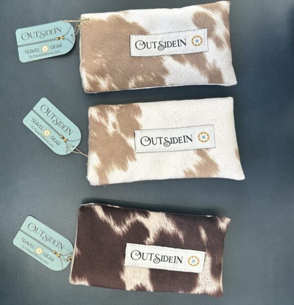 Three cow print pouches with "Outsidein" logo.