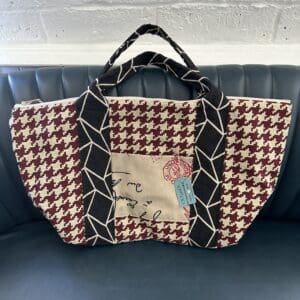 Houndstooth tote bag with black trim.