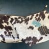 Two cow print zippered pouches.