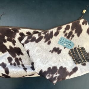 Two cow print zippered pouches.
