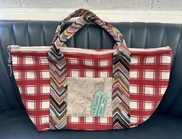 Red and white plaid tote bag with zipper.