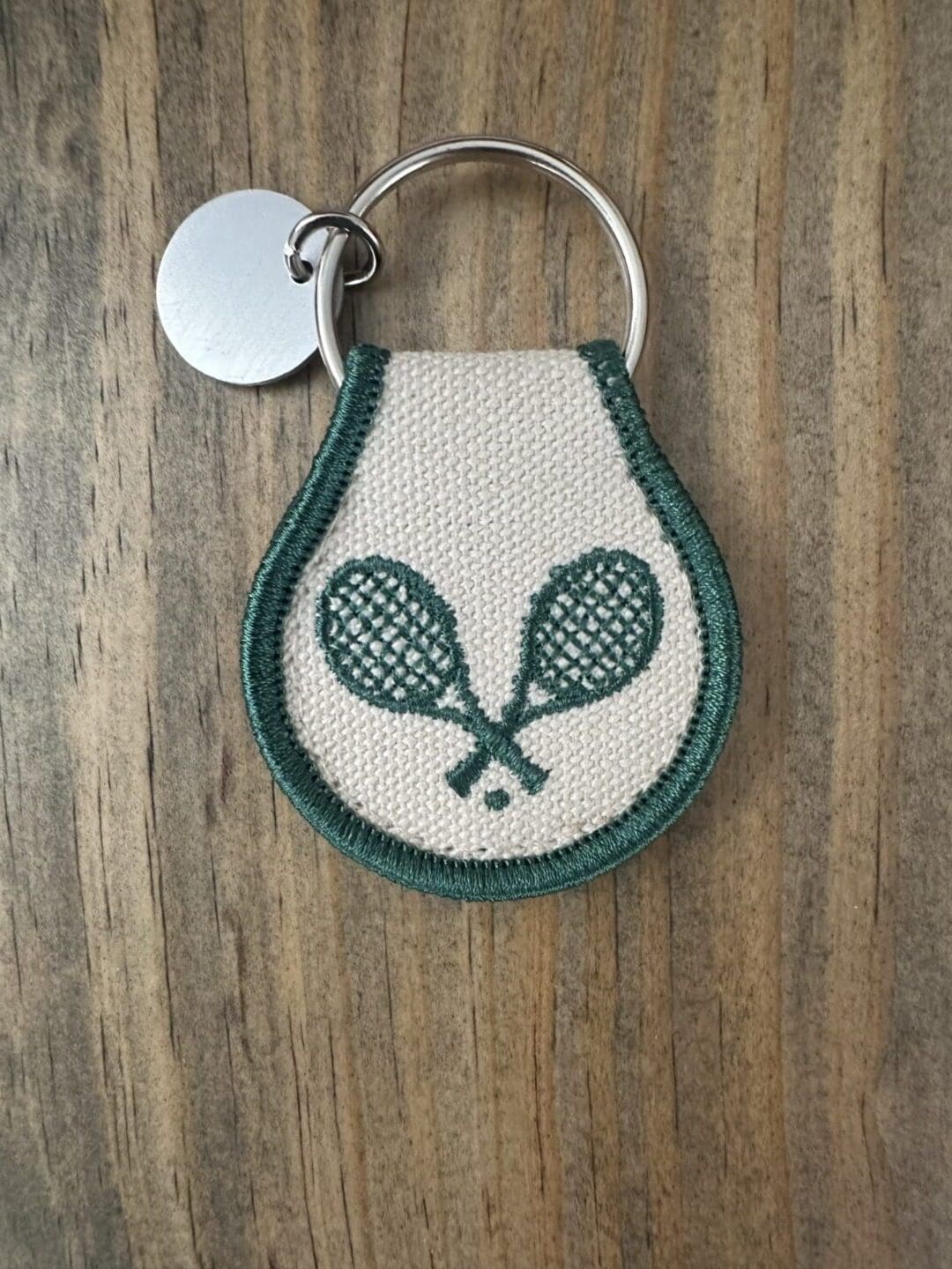 White and green tennis racket keychain.