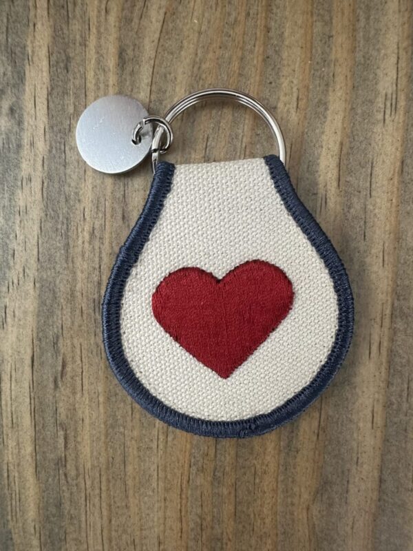 White keychain with a red heart.