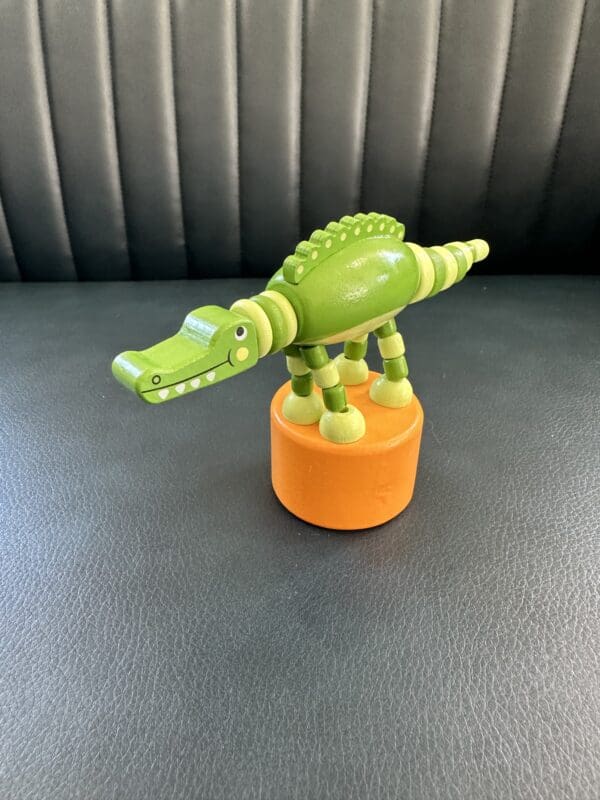 Green wooden alligator puppet toy.