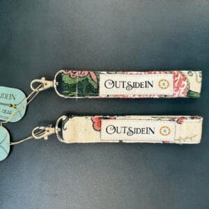 Two fabric keychains with "Outsidein" logo.