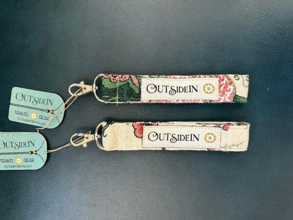 Two fabric keychains with "Outsidein" logo.