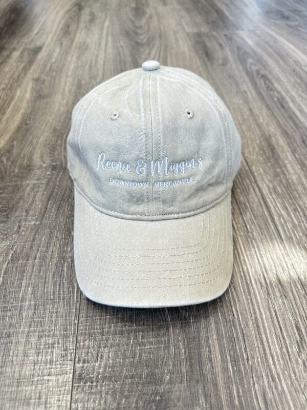 Beige baseball cap with "Reenie & Miggins" logo.