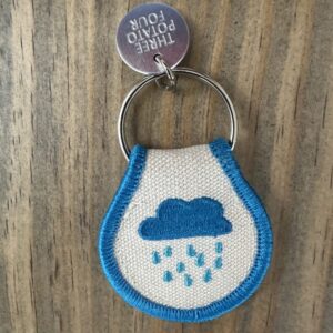 Keychain with blue rain cloud embroidery.
