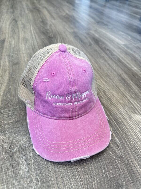 Pink distressed trucker hat with logo.