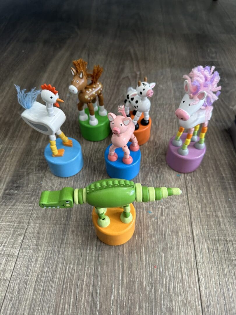 Wooden animal toys on colorful bases.