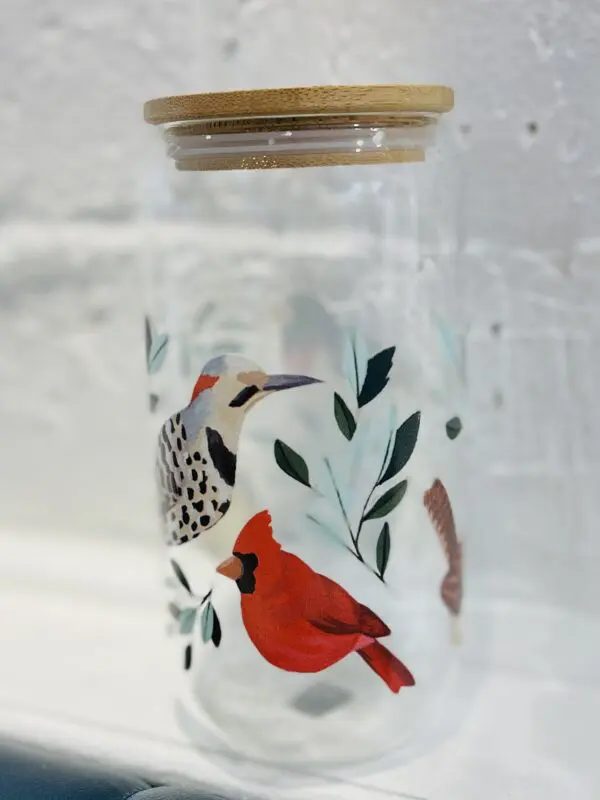 Glass jar with cardinal and woodpecker design.